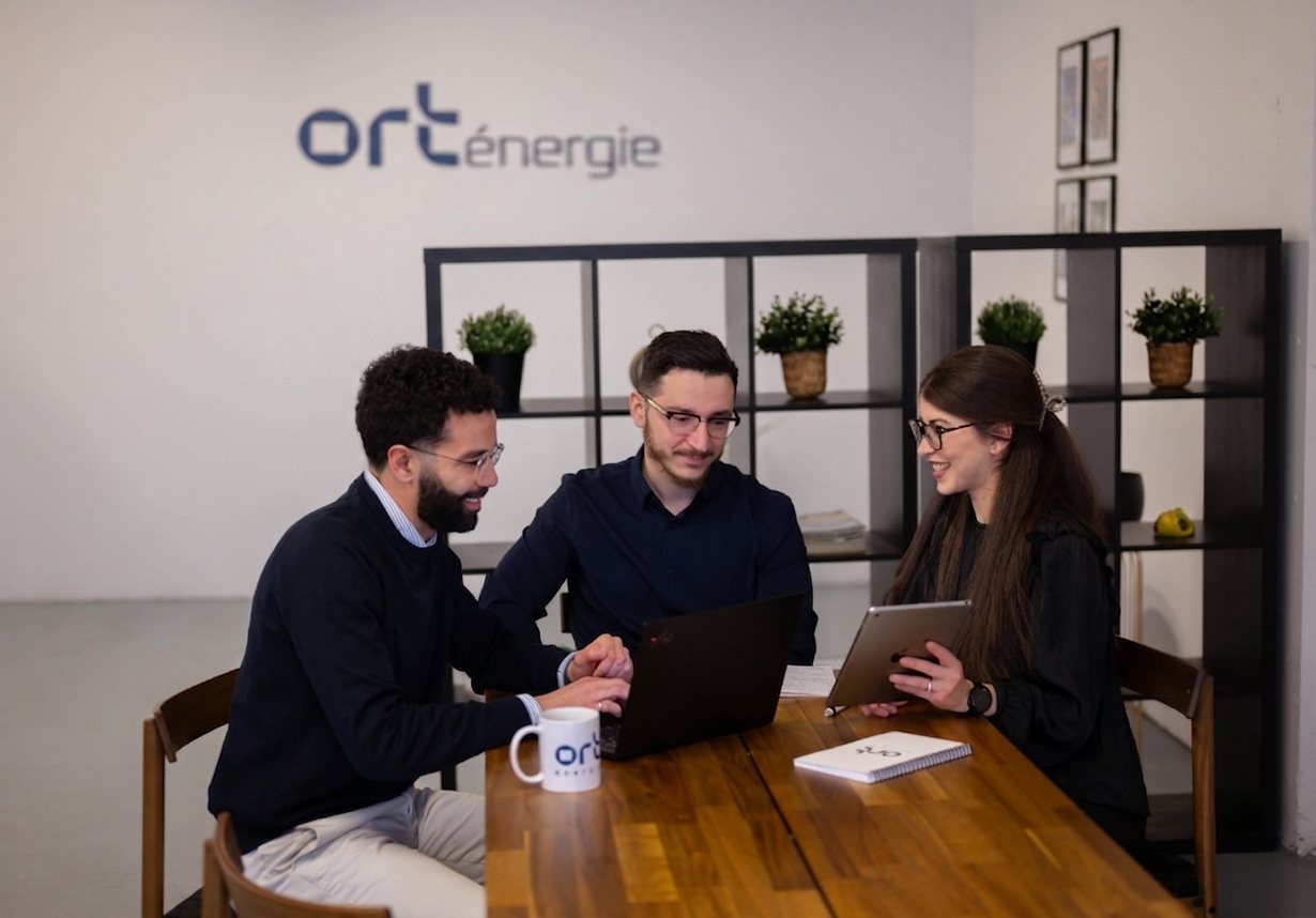 Three ORT Énergie team members working together at a laptop